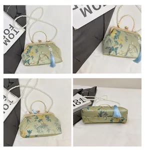 Detail view of light green satin handbag with floral patterns and pearl strap