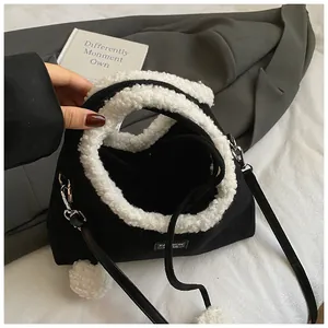 Chic black canvas bucket bag with white faux shearling trim and pompom charms for women