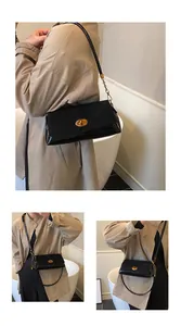 Détail du sac sous le bras en cuir verni noir avec fermoir doré et bandoulière sur trench