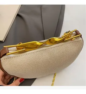 Detailed shot of woven hobo bag featuring a gold twisted metal handle and chain strap