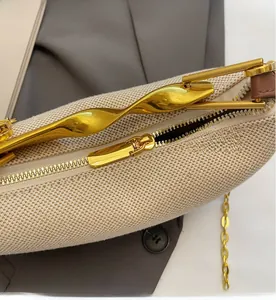 Detail of beige woven fabric bag with gold twist buckle and smooth metallic zipper