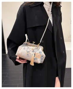 Detailed embroidery of birds and flowers on a vintage white silk cheongsam handbag