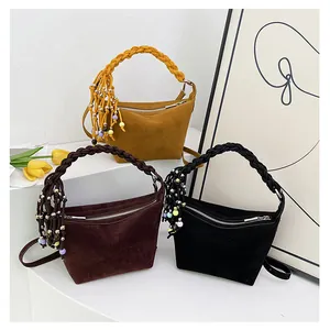Three retro matte handbags in ginger, brown, and black with woven handles and long tassels