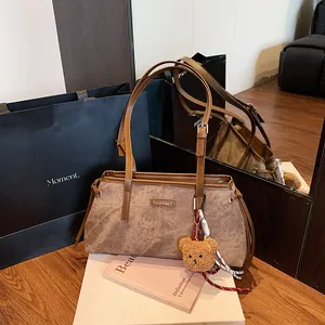 Brown retro tote bag with marble texture and plush bear charm on white display stand