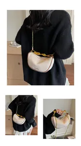 Detail of crescent canvas bag featuring golden twist handle and chic IT CHICK print