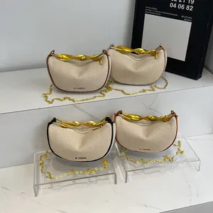 Minimalist canvas dumpling bag with elegant twisted metal handle and gold chain strap