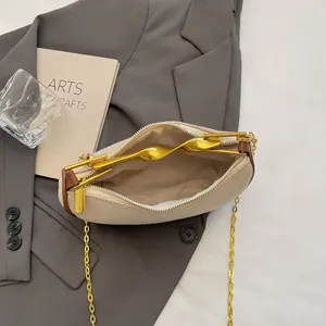 Minimalist beige woven dumpling bag with brown leather trim and gold metal handle