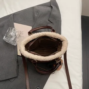 Brown faux leather shoulder bag with plush fleece trim and detachable long strap