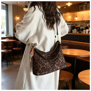 Detail of leopard print hobo bag with zip closure and elegant beaded tassel charm