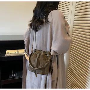 Detail of dark olive green suede bucket bag with long tassels and drawstring closure