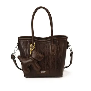 Fashionable dark brown woven crossbody bag with cute dog charm and top handles