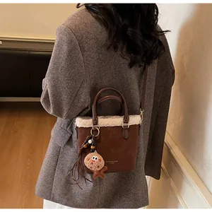 Detail of vintage brown suede tote with white faux fur trim and cute gingerbread man charm