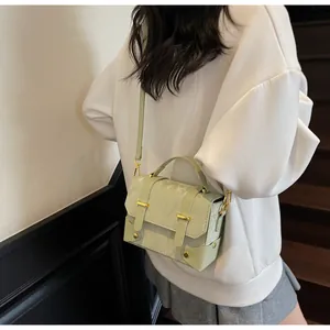 Detail of light green vintage crossbody bag with floral jacquard texture and gold hardware