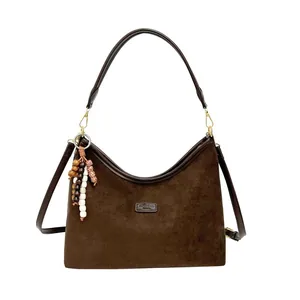 Dark brown suede crescent shoulder bag with leather trim and wooden bead charm accessory