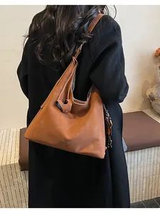 Detail of caramel hobo tote featuring soft leather texture and stylish beaded tassel