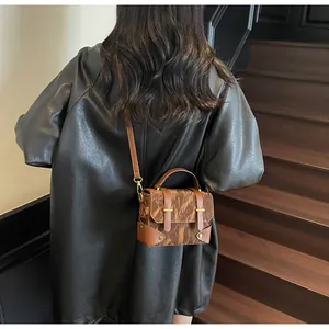Detailed view of a vintage brown square bag styled on a model with rustic textures