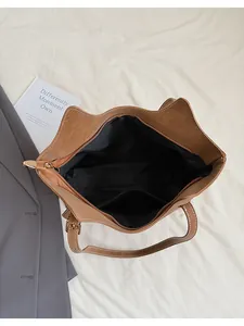 Top view of brown tote bag with contrast stitching, inner pocket, and gold zipper