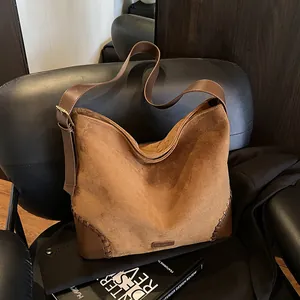 Retro brown suede hobo bag with leather patchwork and adjustable strap in a stylish setting