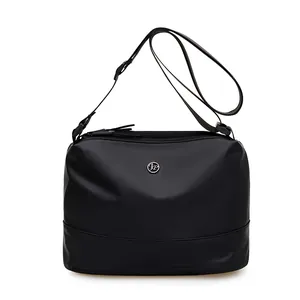 Minimalist black waterproof nylon shoulder bag with adjustable strap and silver logo