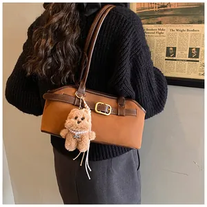 Brown matte baguette shoulder bag with a cute plush bear charm and buckle detail