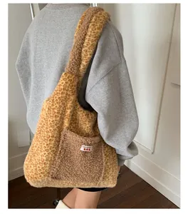 Detail of plush leopard print tote bag with fuzzy brown strap and embroidered cherry tag