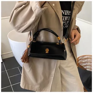Fashionable black faux leather underarm bag styled with a trench coat for an autumn look