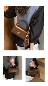 Detail of dark brown leather underarm bag with gold twist lock and woven handle