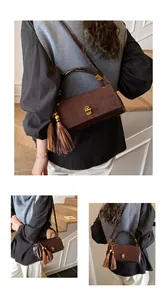 Detail of vintage brown patchwork handbag with gold clasp and stylish tassel pendant
