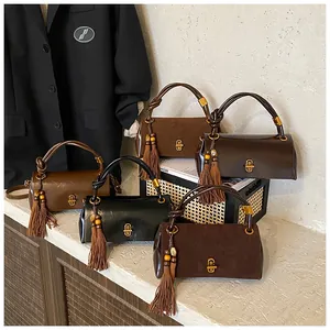 Close-up of retro underarm bags with suede textures, tassel charms and gold twist locks
