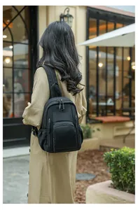 Close-up of black nylon backpack on a model with detailed zippers and water-resistant fabric