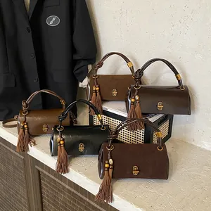 Minimalist leather underarm bags in autumn colors with knot handle and tassel detail