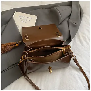 Retro dark brown crossbody underarm bag with metal twist lock and tassel decoration