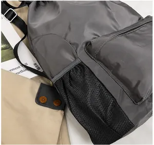Detail of the side mesh pocket on a dark gray waterproof swimming drawstring backpack