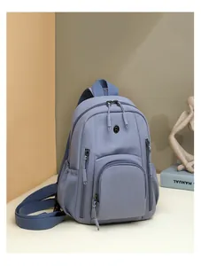 Close-up of durable Morandi blue nylon backpack showing zippered pockets and shoulder straps