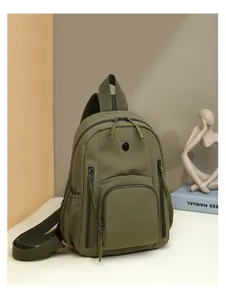 Detail of army green nylon backpack with multiple zipper pockets and circular logo