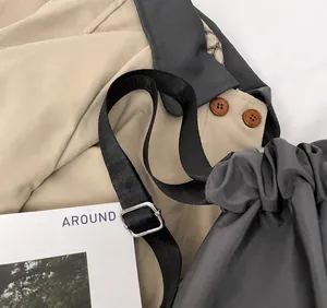 Detail view of adjustable black nylon shoulder strap and silver metal buckle on gray gym bag