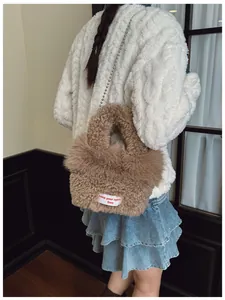 Dettaglio della borsa a secchiello in peluche con trama effetto lana e catena a perle