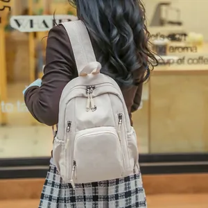 Minimalist beige nylon backpack with multi-pocket design for fashion students