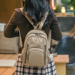 Minimalist khaki nylon backpack for women shown on model in an urban casual setting