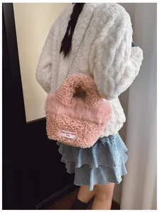 Dettaglio borsa rosa in peluche con manico di perle ed etichetta keep your spirit free