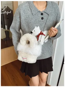Dettaglio borsa di peluche bianca con catena di perle e piccola etichetta rossa