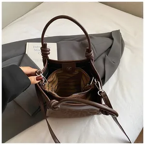 Vue de haut du sac seau montrant la doublure rayée, le zip et la texture léopard
