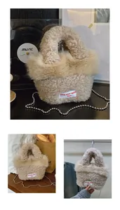 Dettaglio della borsa in peluche beige con catena in metallo e toppa con scritta