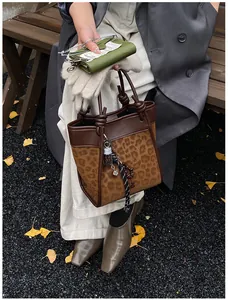 Détail du sac seau léopard avec poignée nouée et style automnal en plein air