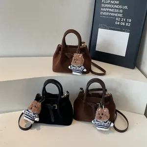 Three pleated vintage tote bags in brown, black, and coffee with bear charms on white steps