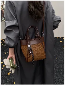 Détail du sac seau léopard avec poignée nouée et accessoires de charme créatifs