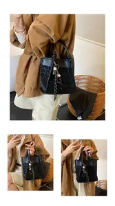 Détail du sac seau léopard avec poignée nouée unique et breloque décorative à pompon