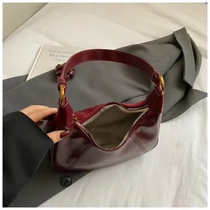 Dettaglio borsa hobo bordeaux con finiture dorate e trama in pelle scamosciata