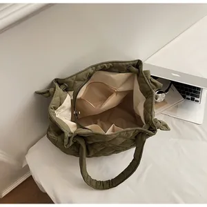 Vue détaillée du sac cabas matelassé vert olive montrant la doublure et les poches