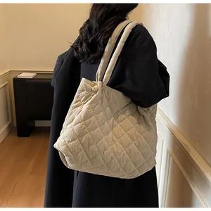Vue détaillée du grand sac cabas beige matelassé avec bandoulière à nœud porté par le mannequin